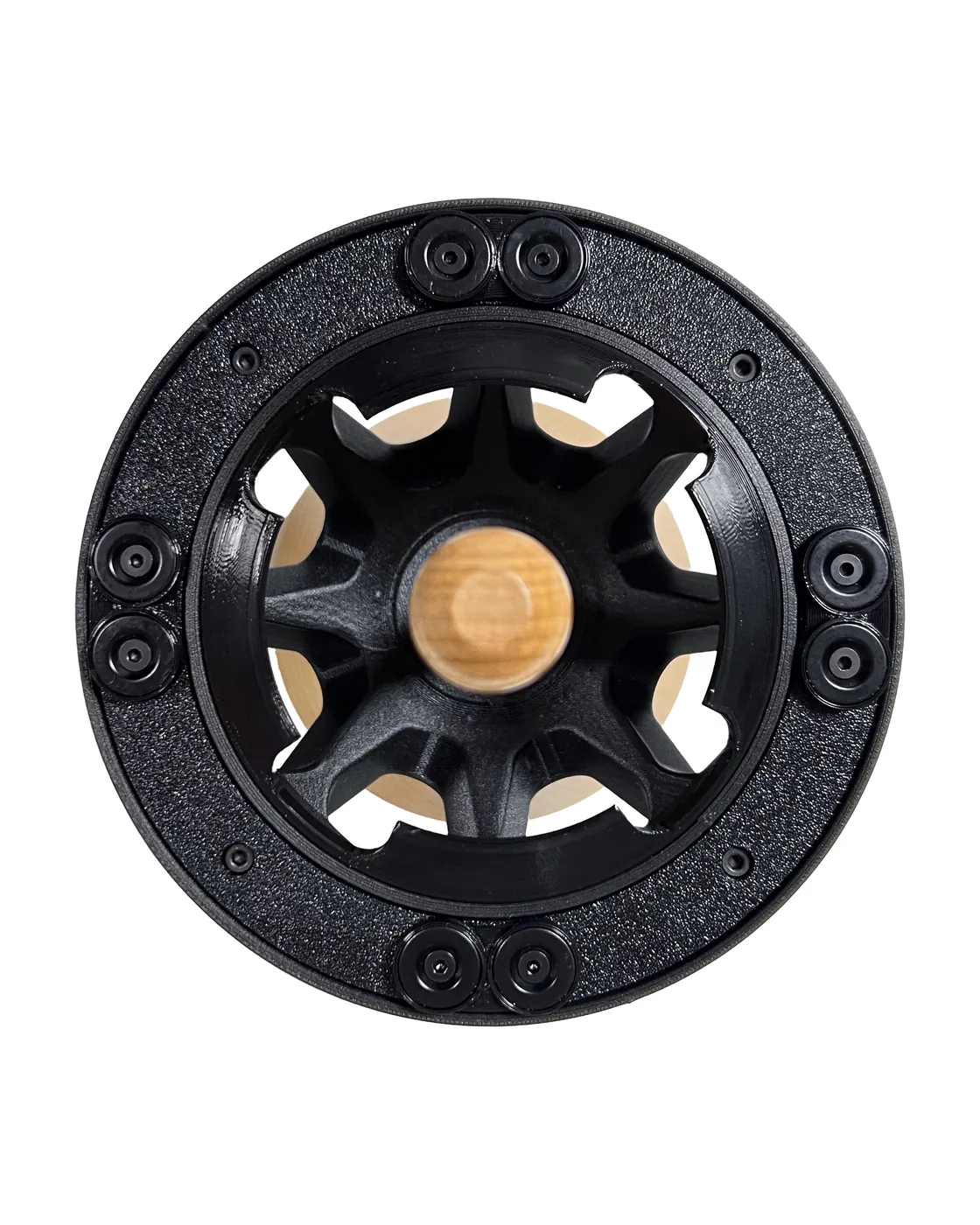 The floating disc of the Atlas All seen from above: a black crown carrying eight round magnets arranged in pairs, with the light wooden centring rod in the middle.