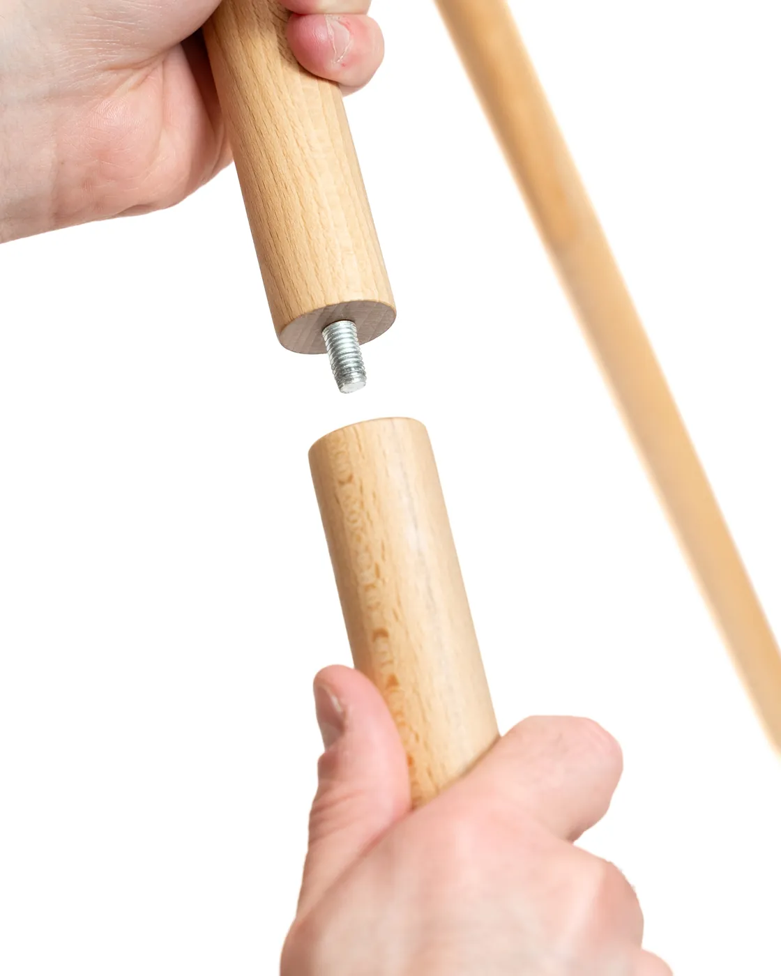 Two hands screwing a wooden Atlas All extension onto a leg, with the metal threaded insert visible.